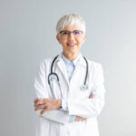 Portrait of confident smiling female doctor. Mature medical professional is wearing lab coat and stethoscope.
